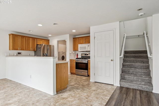 kitchen with stacked washer / drying machine and appliances with stainless steel finishes