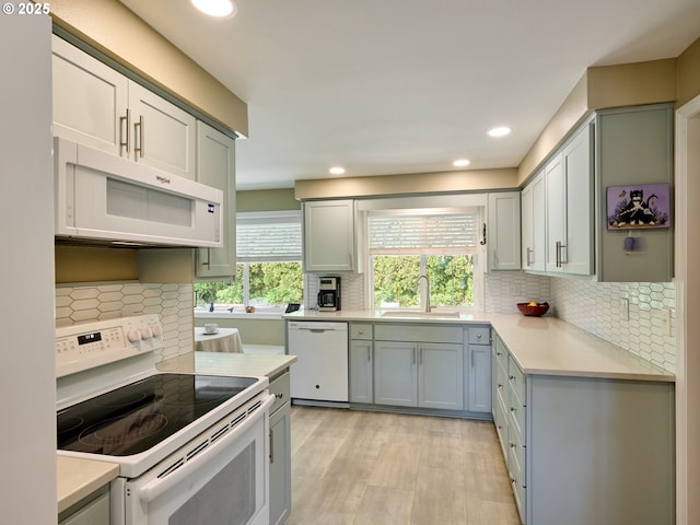 2235 Juntura Ct S, Salem, OR 97302 - kitchen with tasteful backsplash, a sink, light countertops, light wood-style floors, and white appliances