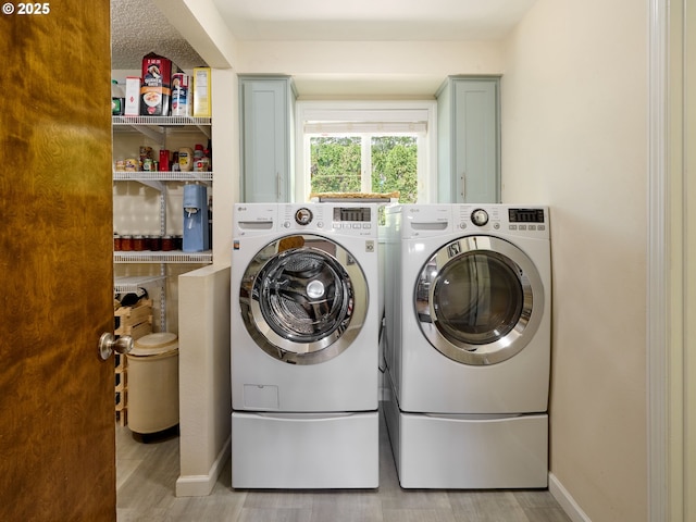 2235 Juntura Ct S, Salem, OR 97302 - laundry room with light wood-style floors, cabinet space, independent washer and dryer, and baseboards