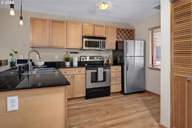 1040 NW Naito Pkwy Unit O-10, Portland, OR 97209 - kitchen with stainless steel appliances, light brown cabinetry, dark countertops, light wood-type flooring, and decorative light fixtures