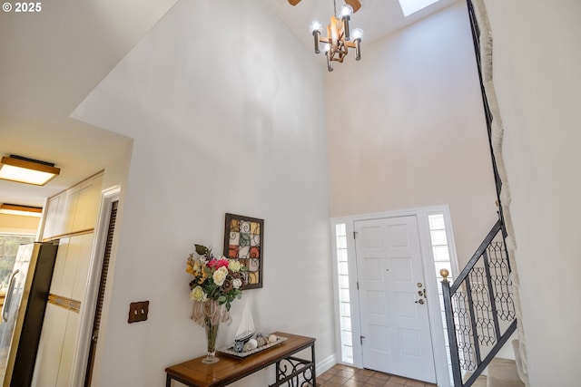 tiled foyer with a chandelier