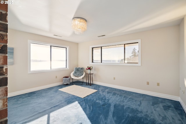 sitting room featuring dark colored carpet and a chandelier