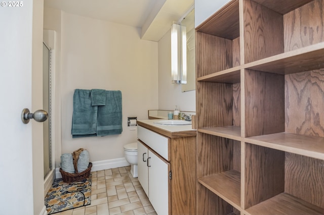 bathroom featuring vanity, toilet, and a shower with door