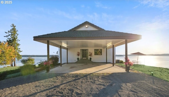 back of house with a water view and a carport