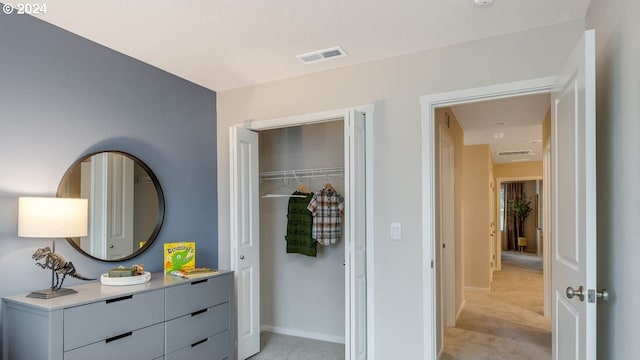 bedroom featuring visible vents, light carpet, baseboards, and a closet