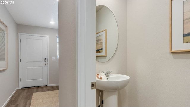 bathroom with a sink, baseboards, and wood finished floors