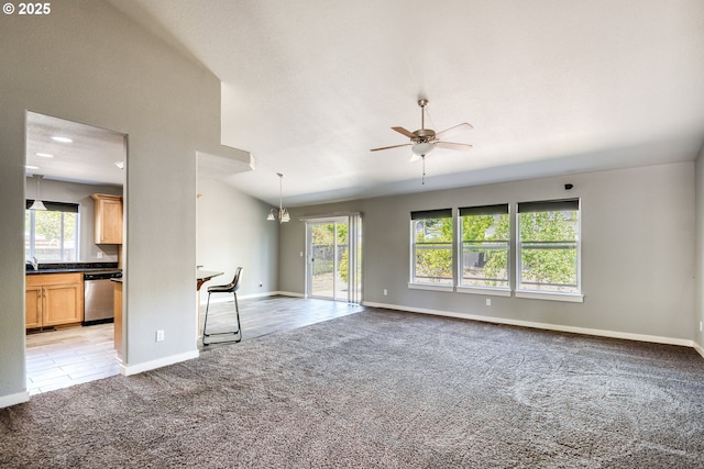 1545 E Fourth Ave, Sutherlin, OR 97479 - unfurnished living room featuring light colored carpet, healthy amount of natural light, ceiling fan, and baseboards