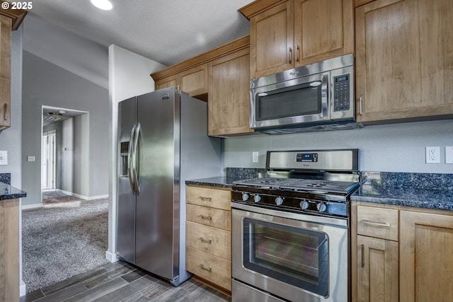 1545 E Fourth Ave, Sutherlin, OR 97479 - kitchen featuring stainless steel appliances, lofted ceiling, dark wood finished floors, dark stone countertops, and baseboards