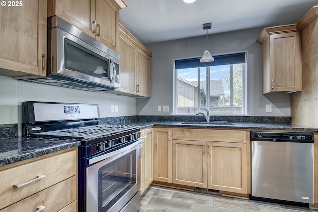 1545 E Fourth Ave, Sutherlin, OR 97479 - kitchen featuring appliances with stainless steel finishes, a sink, light brown cabinetry, and dark stone countertops