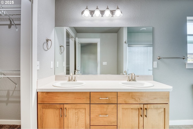 1545 E Fourth Ave, Sutherlin, OR 97479 - bathroom featuring a spacious closet, double vanity, a textured wall, and a shower with door
