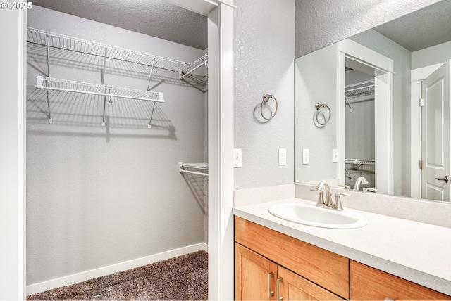 1545 E Fourth Ave, Sutherlin, OR 97479 - bathroom with vanity, a walk in closet, and baseboards