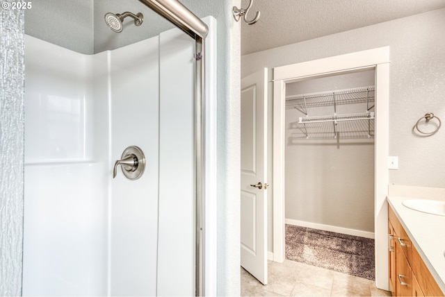 1545 E Fourth Ave, Sutherlin, OR 97479 - bathroom featuring vanity, a shower stall, a walk in closet, and tile patterned flooring