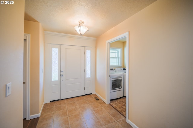 foyer entrance featuring washer and clothes dryer and a textured ceiling