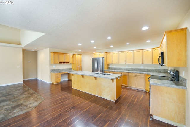 kitchen featuring a breakfast bar area, stainless steel refrigerator, a kitchen island with sink, dark hardwood / wood-style flooring, and light brown cabinets