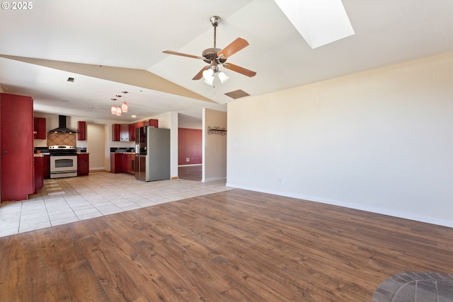 400 S 28th Ave, Cornelius, OR 97113 - unfurnished living room with light wood-type flooring, vaulted ceiling, a ceiling fan, a skylight, and baseboards