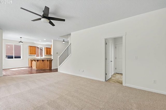 unfurnished living room featuring recessed lighting, ceiling fan, light colored carpet, and baseboards