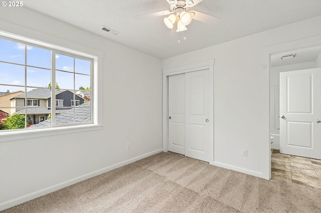 unfurnished bedroom with baseboards, carpet, visible vents, and a closet