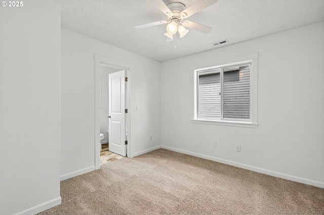 unfurnished room featuring carpet floors, a textured ceiling, a ceiling fan, baseboards, and visible vents