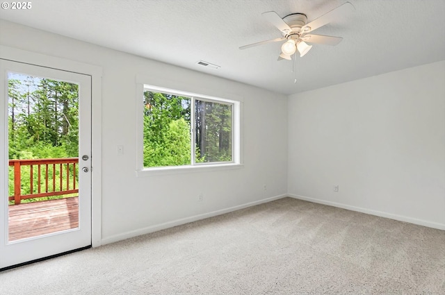 spare room featuring ceiling fan, visible vents, baseboards, and carpet