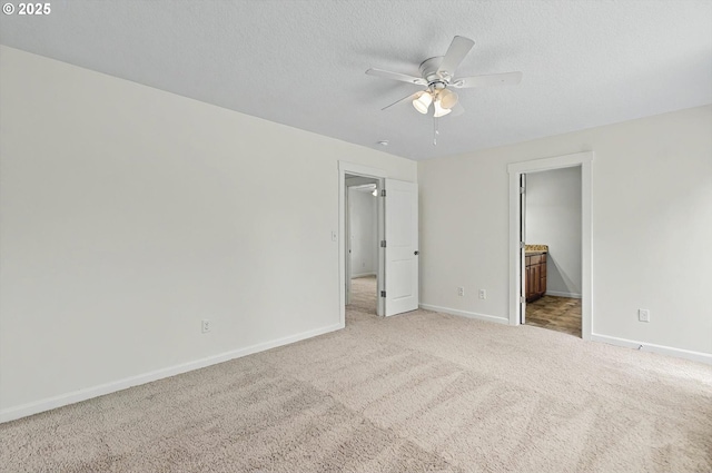 unfurnished bedroom with connected bathroom, a textured ceiling, baseboards, and carpet