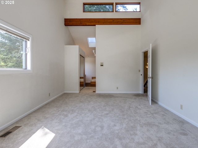 7785 SW W Slope Dr, Portland, OR 97225 - unfurnished living room featuring a high ceiling, carpet, and a skylight
