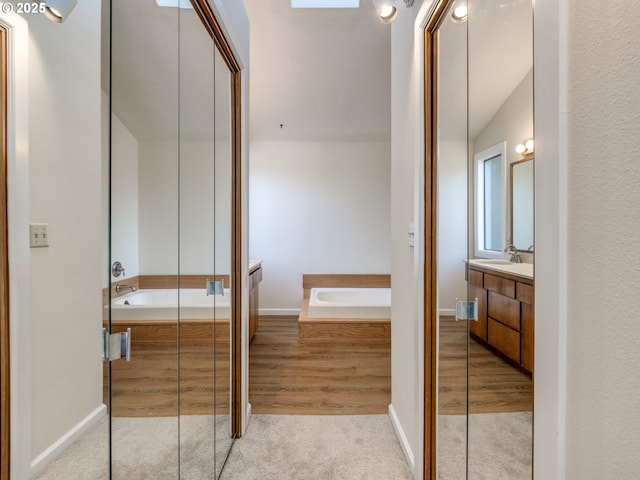 7785 SW W Slope Dr, Portland, OR 97225 - full bathroom with vanity, a bath, and wood finished floors