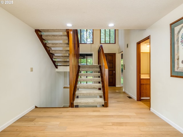 7785 SW W Slope Dr, Portland, OR 97225 - stairs with wood finished floors, recessed lighting, and a textured ceiling