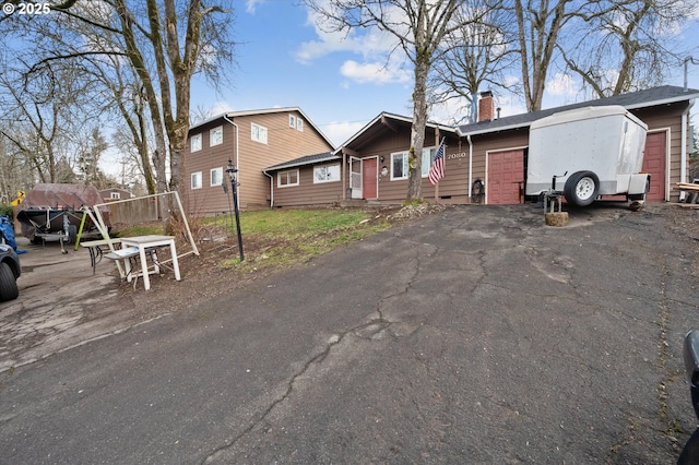 7080 SW Taylors Ferry Rd, Portland, OR 97223 - view of front facade featuring a garage and a chimney