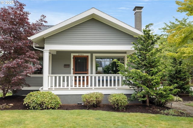 2904 NE 51st Ave, Portland, OR 97213 - view of front of home featuring covered porch, a chimney, and a front lawn
