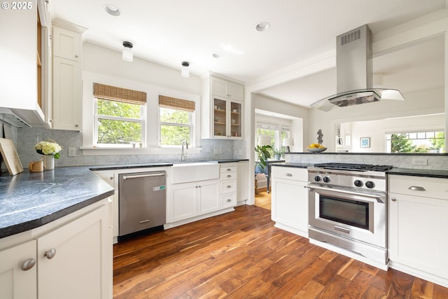 2904 NE 51st Ave, Portland, OR 97213 - kitchen featuring appliances with stainless steel finishes, island range hood, dark countertops, a sink, and tasteful backsplash