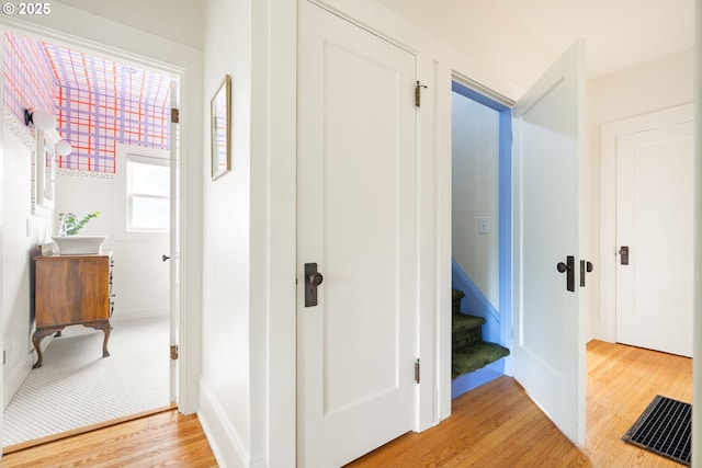 2904 NE 51st Ave, Portland, OR 97213 - hall with light wood-style flooring, stairs, a sink, and baseboards