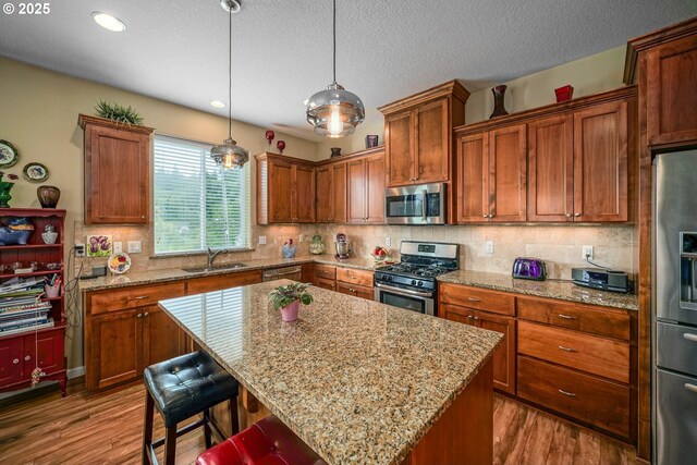 2356 Benjamin Ave, Salem, OR 97304 - kitchen with stainless steel appliances, a sink, wood finished floors, a kitchen island, and recessed lighting