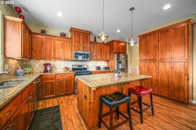 2356 Benjamin Ave, Salem, OR 97304 - kitchen with stainless steel appliances, a sink, wood finished floors, backsplash, and a textured ceiling