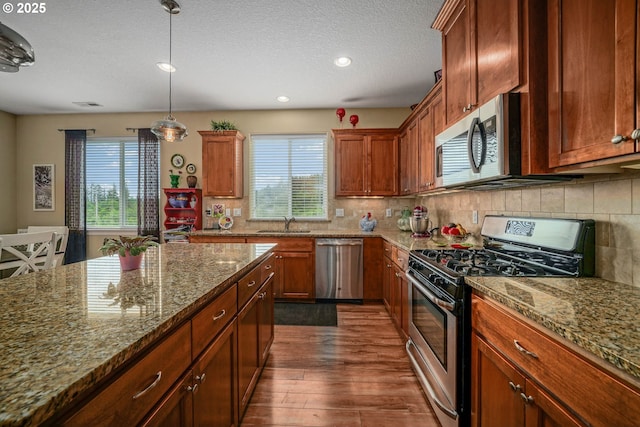 2356 Benjamin Ave, Salem, OR 97304 - kitchen with stainless steel appliances, healthy amount of natural light, dark wood-style floors, decorative backsplash, and a textured ceiling
