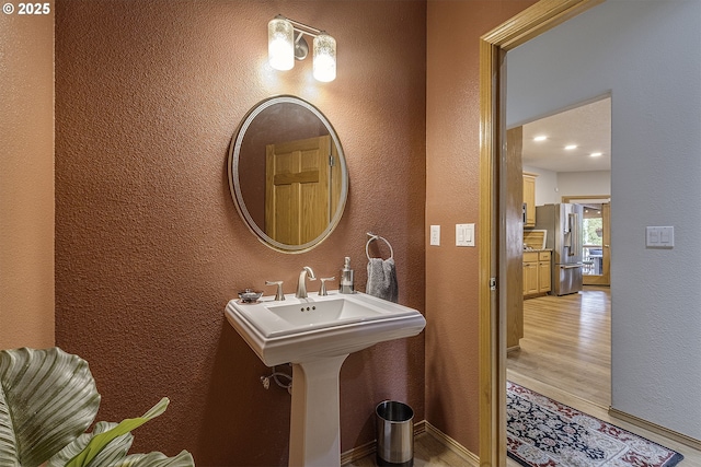 610 NE Sundance Ct, Hillsboro, OR 97124 - bathroom with a textured wall, wood finished floors, baseboards, and a sink