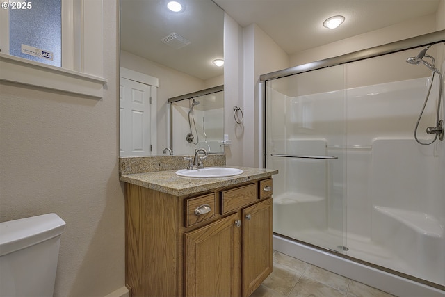 610 NE Sundance Ct, Hillsboro, OR 97124 - full bathroom featuring a shower stall, vanity, toilet, and tile patterned flooring