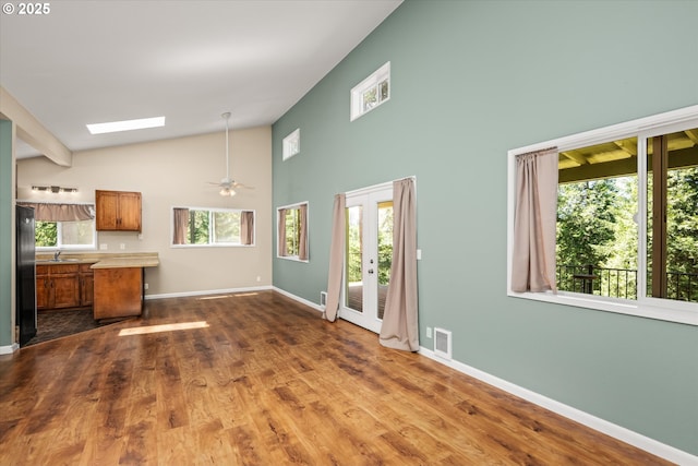32475 Beymer Rd, Eugene, OR 97405 - unfurnished living room featuring a sink, a skylight, baseboards, dark wood-style floors, and high vaulted ceiling