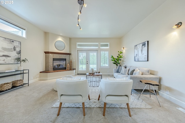 living room featuring carpet floors, baseboards, and a tile fireplace