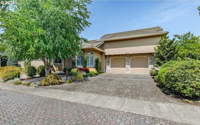 view of front of property with a garage, stone siding, and concrete driveway