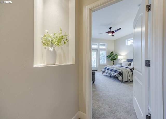 carpeted bedroom with ceiling fan and baseboards