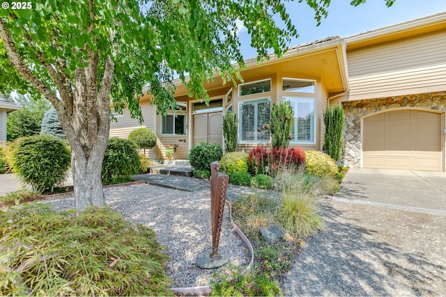 view of front of property featuring driveway and stone siding