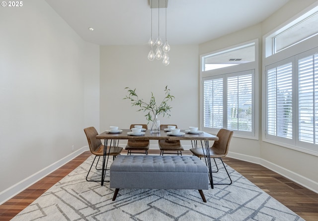 dining room with a notable chandelier, wood finished floors, and baseboards