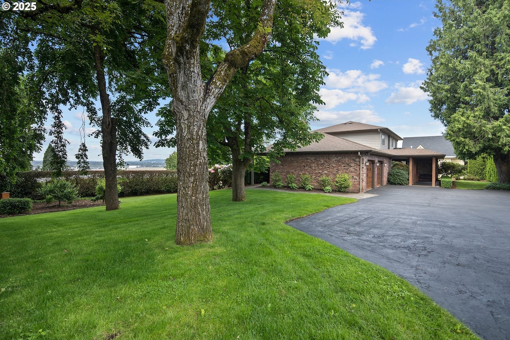 8215 SE Schwind Cir, Vancouver, WA 98664 - view of front of property with asphalt driveway, brick siding, a front yard, an attached garage, and a shingled roof