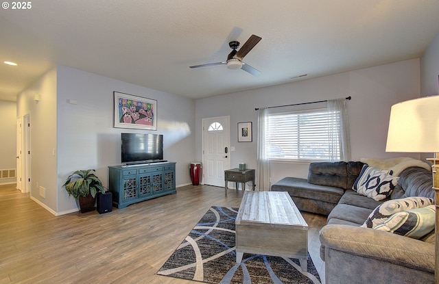 living room featuring wood-type flooring and ceiling fan