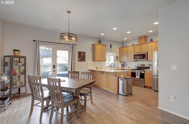 dining space featuring sink, light hardwood / wood-style floors, and a healthy amount of sunlight