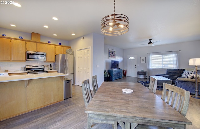 dining room with ceiling fan and light hardwood / wood-style flooring