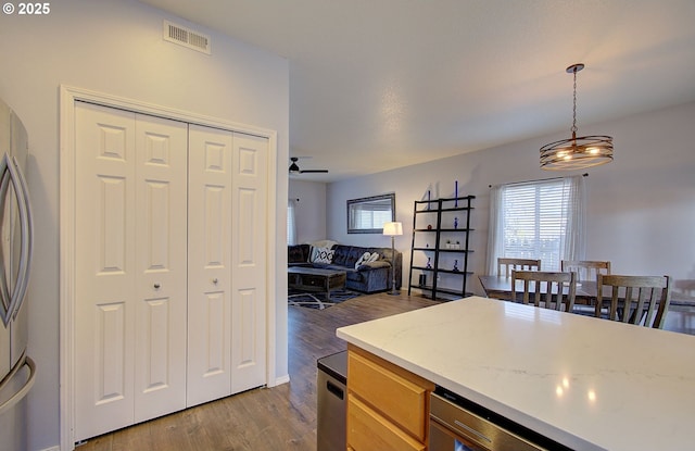 kitchen featuring ceiling fan, light brown cabinets, dark hardwood / wood-style flooring, and decorative light fixtures