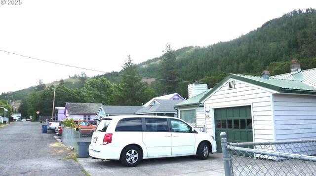 610 Bluff Rd, Klickitat, WA 98628 - view of home's exterior with a metal roof, a forest view, a chimney, and driveway