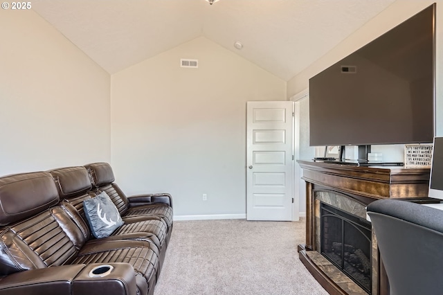 living room featuring visible vents, a fireplace with raised hearth, baseboards, vaulted ceiling, and carpet floors