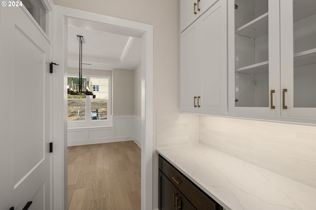 17733 NW Layla Ter Lot 6, Portland, OR 97229 - bar featuring light wood finished floors, a wainscoted wall, a tray ceiling, and a chandelier
